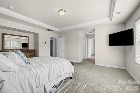 a spacious bedroom with a bed and a flat screen tv