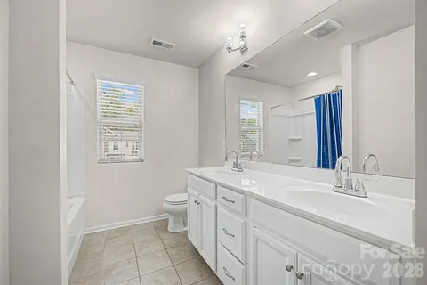 a bathroom with a double vanity sink toilet and a mirror