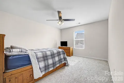 a bedroom with a bed dresser and a window