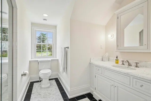 a bathroom with a sink a toilet and a mirror