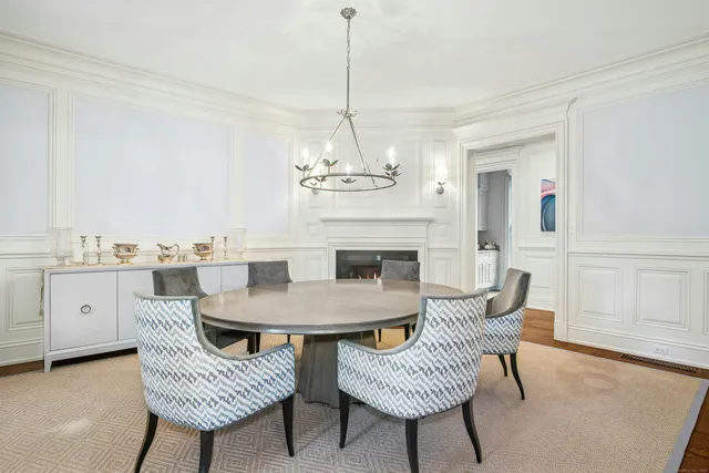 a dining room with furniture a chandelier and wooden floor