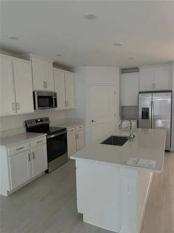 a kitchen with granite countertop white cabinets and stainless steel appliances