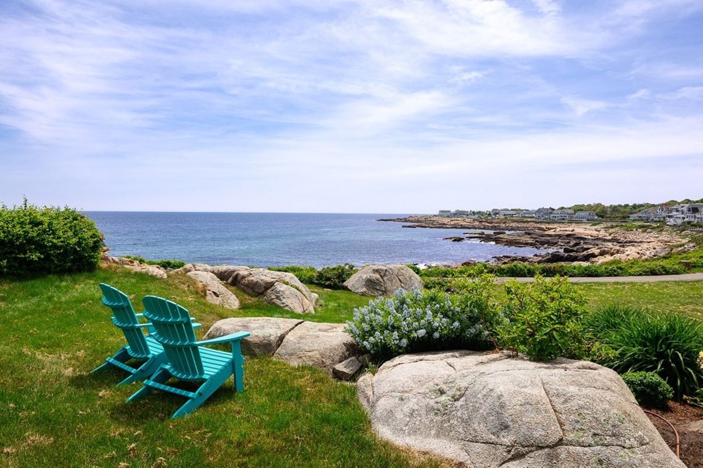 7 Bass Rocks Road Gloucester, MA 01930 - Photo 2 of 36 a view of a backyard with lawn chairs under an umbrella