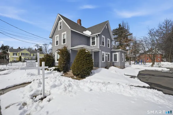 a front view of a house with a yard covered in snow