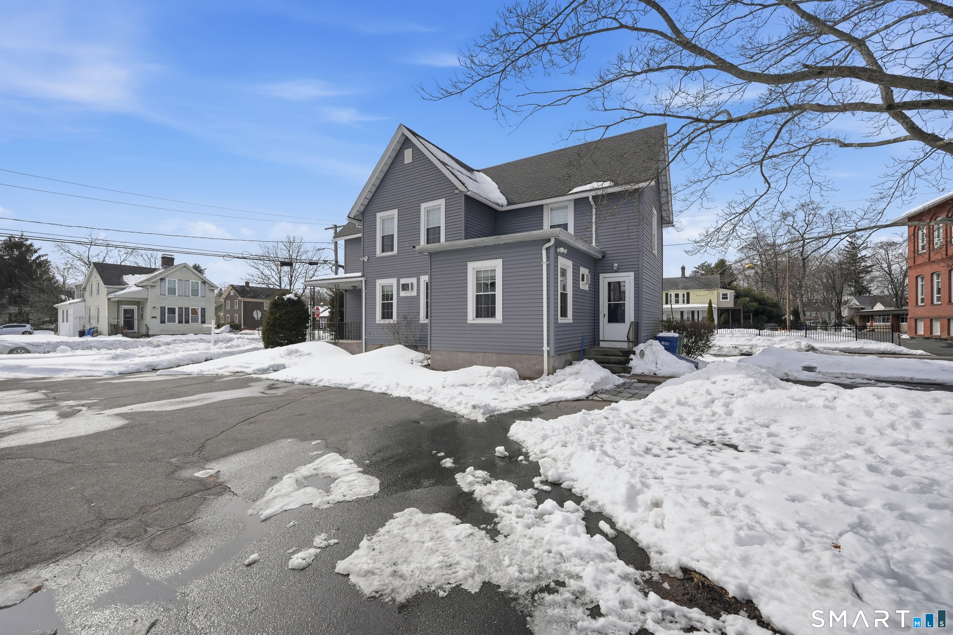 66 Maple Avenue Windsor, CT 06095 - Photo 8 of 38 a front view of a house with a yard covered in snow