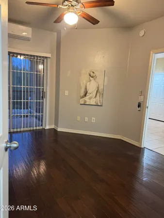 an empty room with wooden floor and window