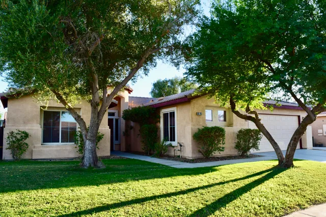 a view of a house with backyard and a tree