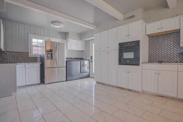a view of a kitchen with granite countertop cabinets and chandelier