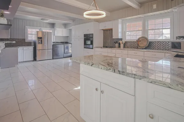 a large kitchen with cabinets and stainless steel appliances