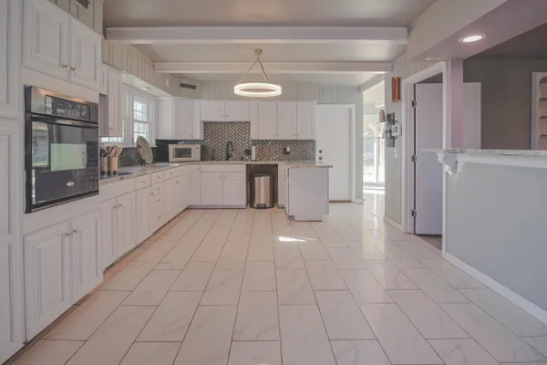 a view of an empty room with wooden floor and a fireplace