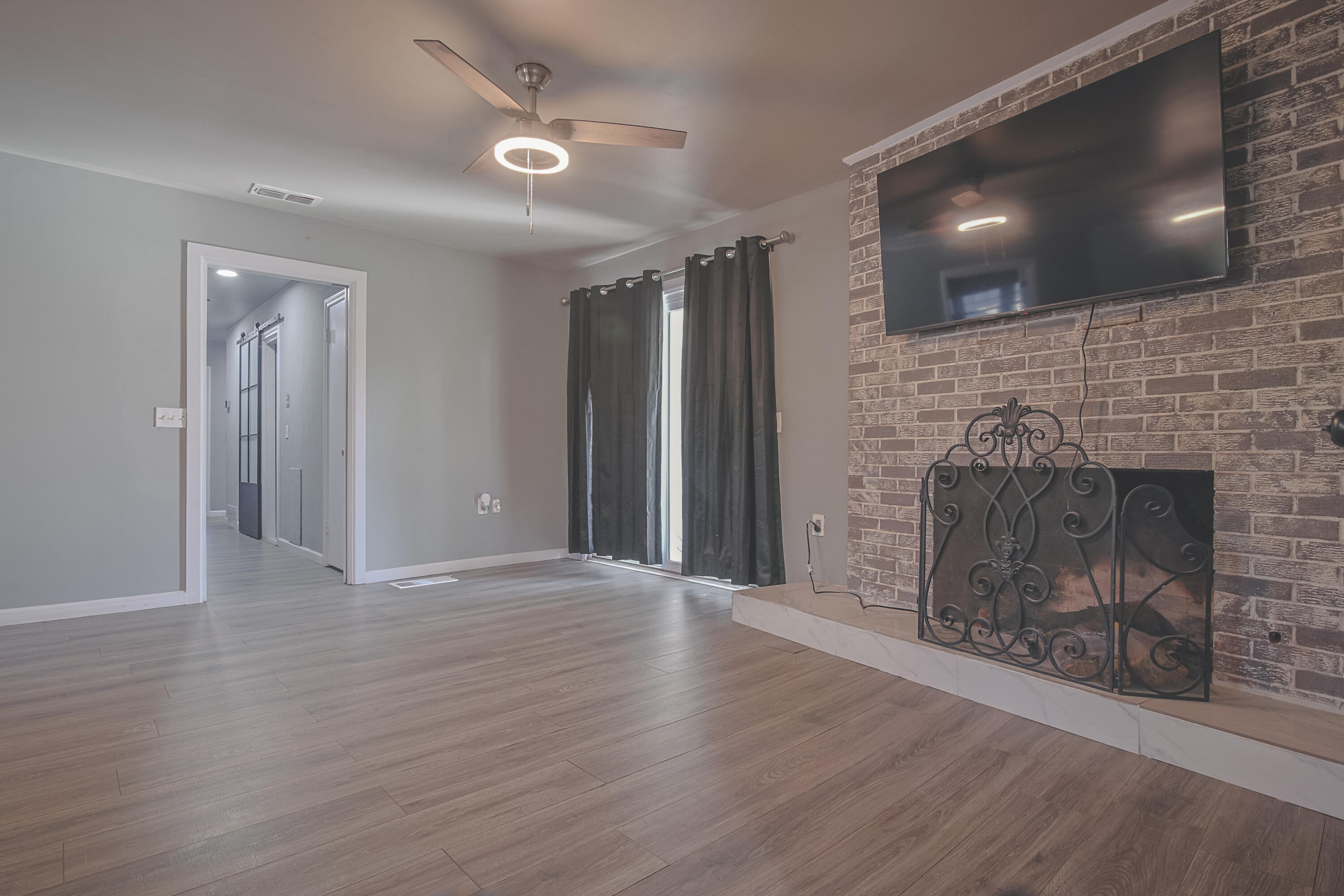 3407 Canyon Road Lubbock, TX 79403 - Photo 18 of 37 a view of an empty room with wooden floor and a fireplace
