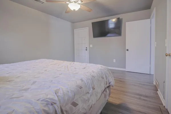 a living room with hard wood floors and a ceiling fan