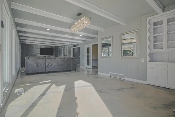 en empty room with windows and ceiling fan