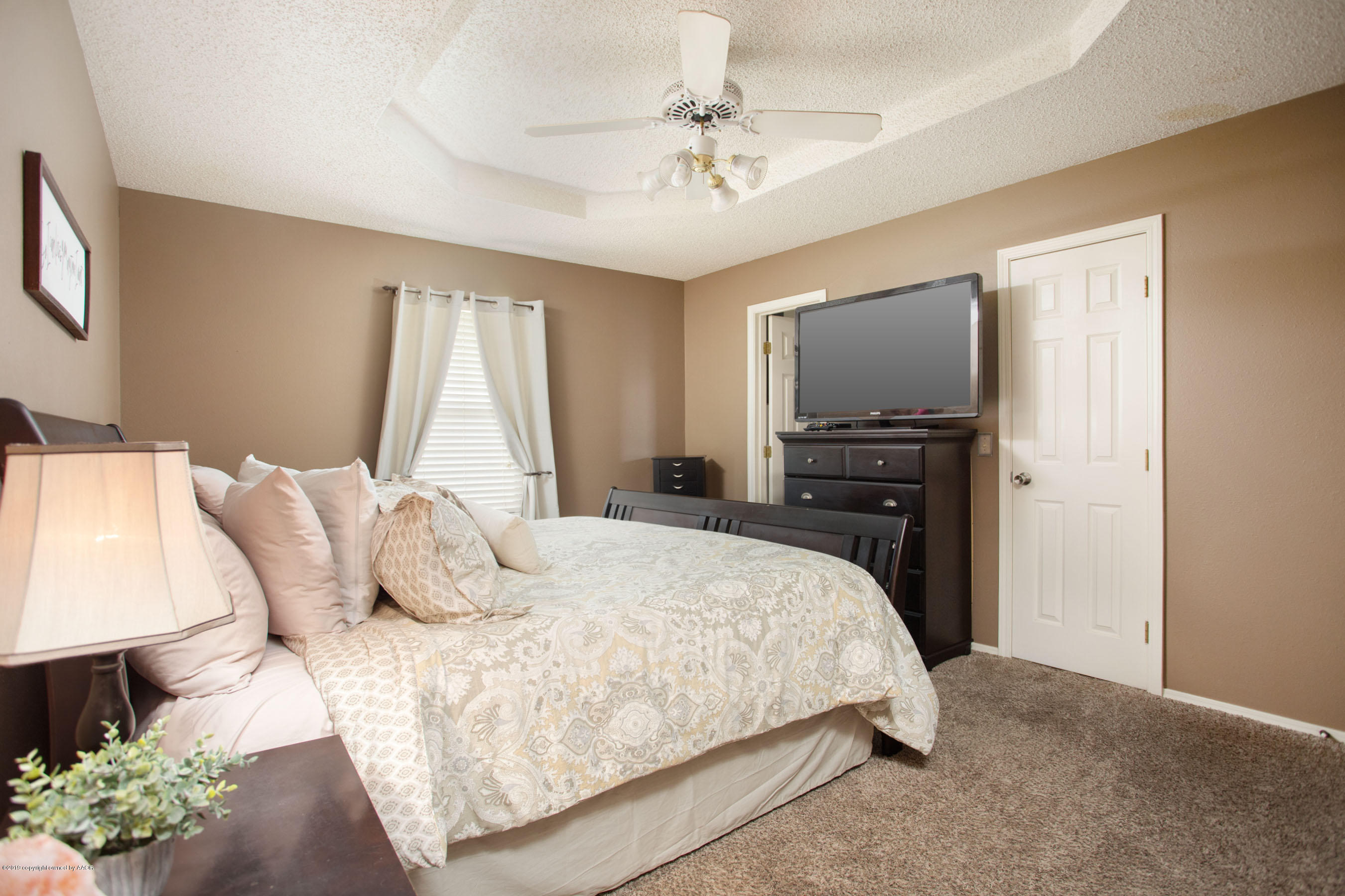8007 Arbor Street Amarillo, TX 79110 - Photo 18 of 25 a bedroom with a bed and a flat screen tv