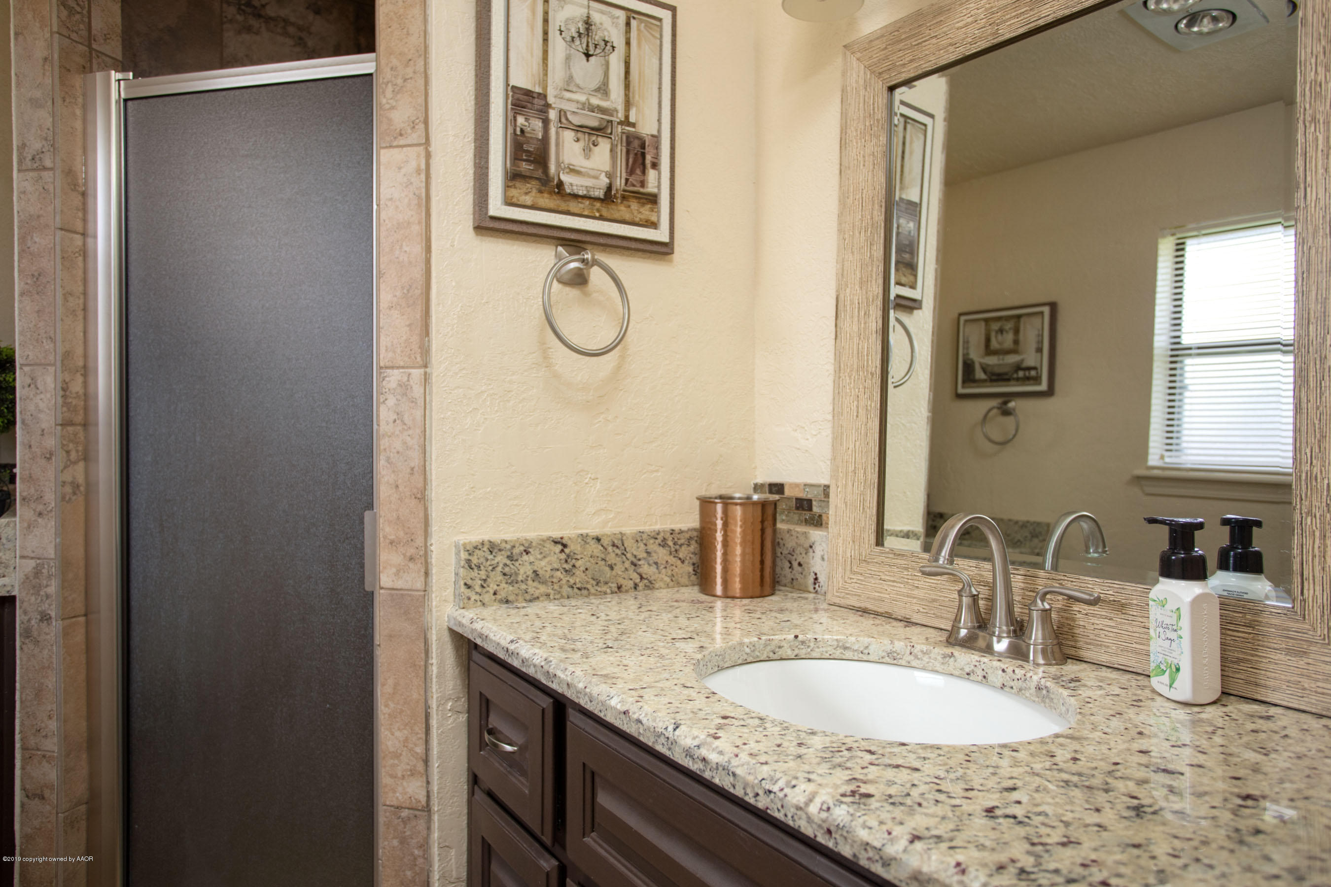 8007 Arbor Street Amarillo, TX 79110 - Photo 20 of 25 a bathroom with a granite countertop sink and a mirror