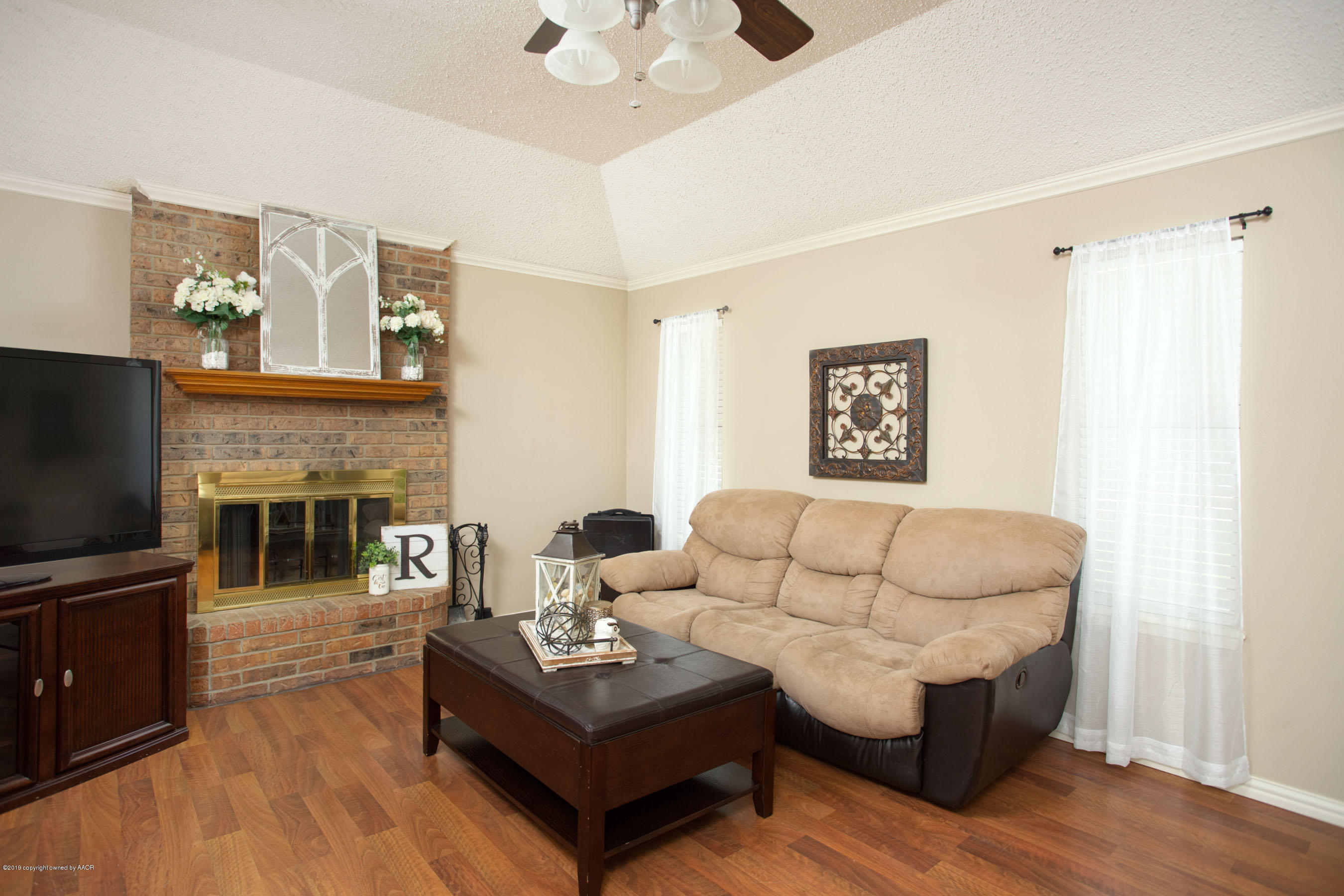 8007 Arbor Street Amarillo, TX 79110 - Photo 6 of 25 a living room with furniture a fireplace and a flat screen tv