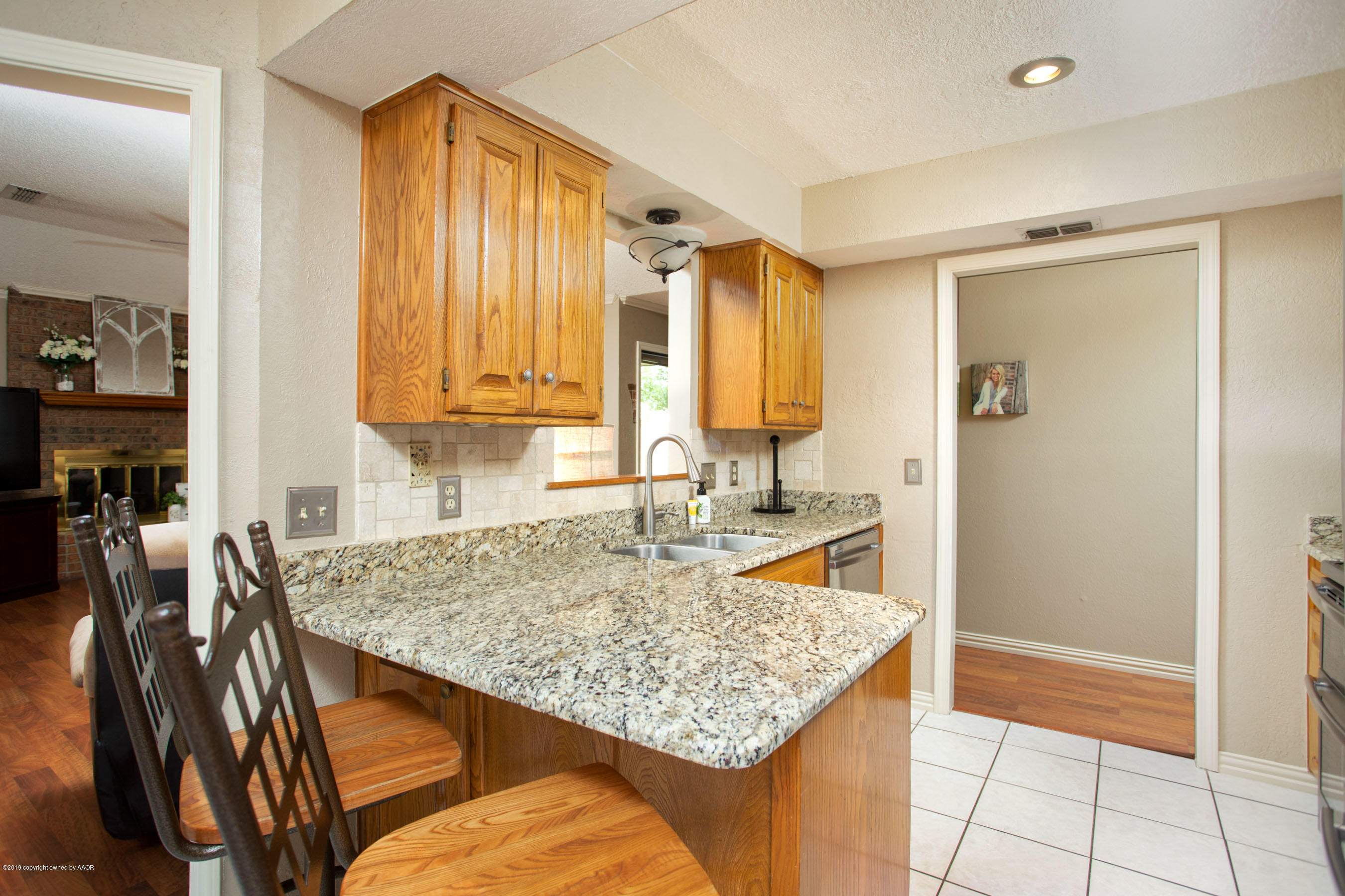 8007 Arbor Street Amarillo, TX 79110 - Photo 9 of 25 a kitchen with a granite countertop sink and cabinets