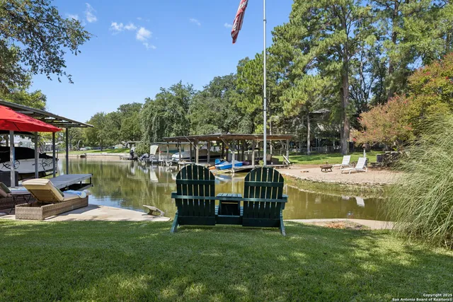 a view of swimming pool with lawn chairs and a fire pit