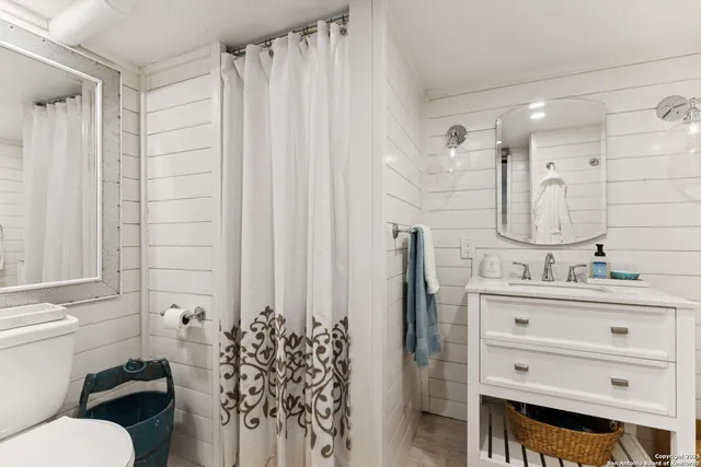 a bathroom with a granite countertop sink toilet and shower