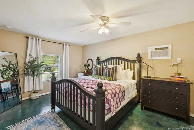 a bedroom with a bed a chandelier and a window