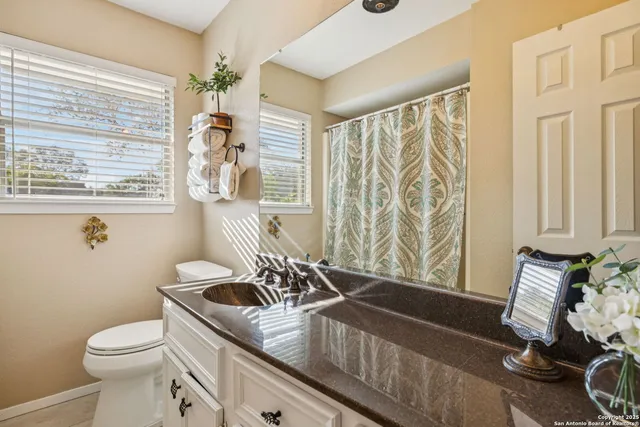 a bathroom with a granite countertop sink a toilet and a bathtub