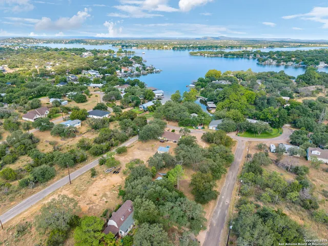 an aerial view of residential house with outdoor space and trees all around