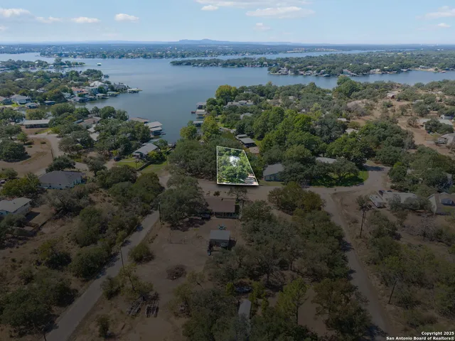 an aerial view of residential houses with outdoor space and trees