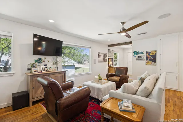 a living room with furniture a flat screen tv and a large window