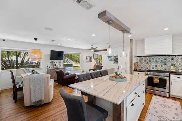 a large kitchen with kitchen island a stove a sink a dining table and chairs