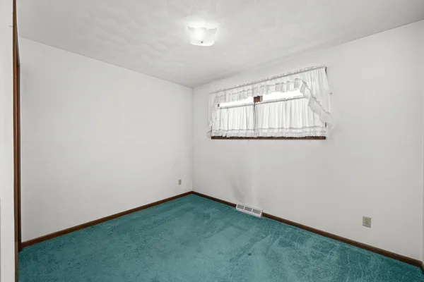 a view of empty room with a fireplace and window