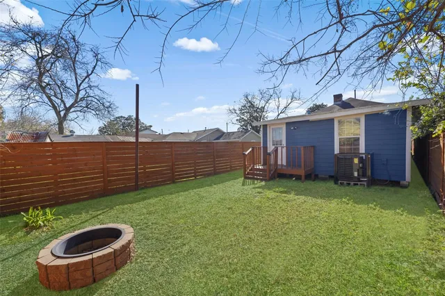 a view of a backyard with potted plants and large tree