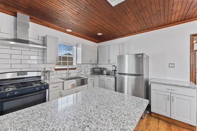 a kitchen with refrigerator cabinets and wooden floor