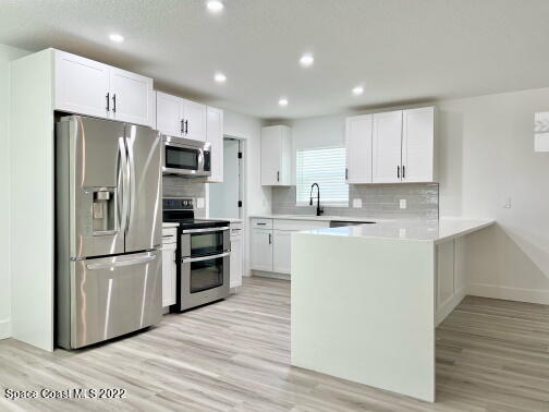 998 Cardon Drive Rockledge, FL 32955 - Photo 5 of 21 a kitchen with a refrigerator a stove top oven and wooden floor