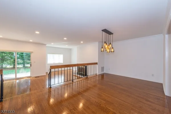 a view of empty room with wooden floor and windows