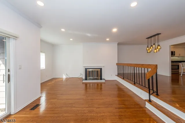 a view of a livingroom with wooden floor and a ceiling fan