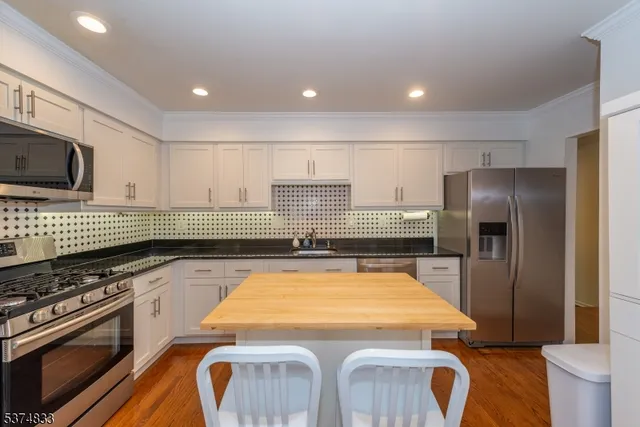 a kitchen with kitchen island a counter space a sink and stainless steel appliances