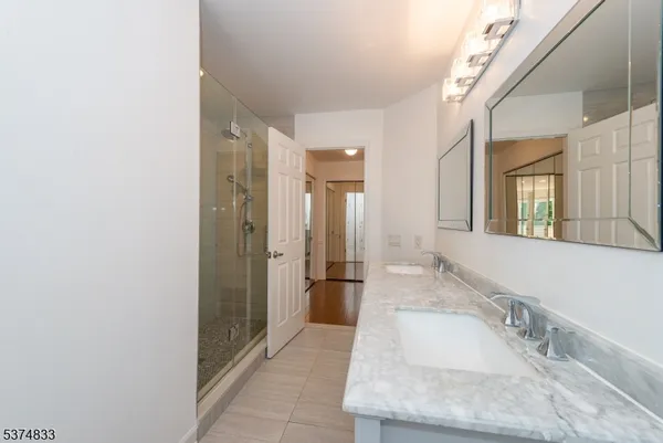 a bathroom with a granite countertop sink a shower and a mirror
