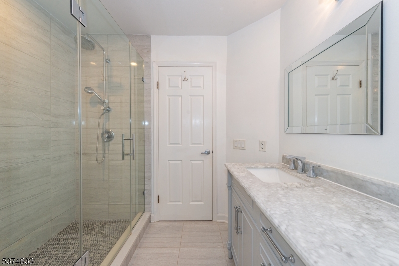3 Avery Court Madison, NJ 07940 - Photo 43 of 50 a bathroom with a granite countertop sink a shower and a mirror