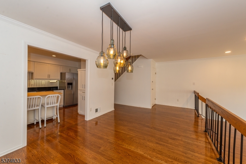 3 Avery Court Madison, NJ 07940 - Photo 10 of 50 a view of an empty room with wooden floor and a kitchen