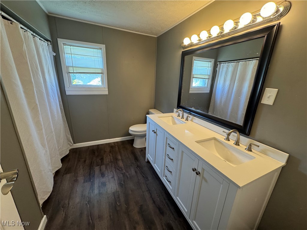 2660 Ridge Road Zanesville, OH 43701 - Photo 16 of 20 Full bath featuring a textured ceiling, wood finished floors, double vanity, crown molding, and a shower with shower curtain