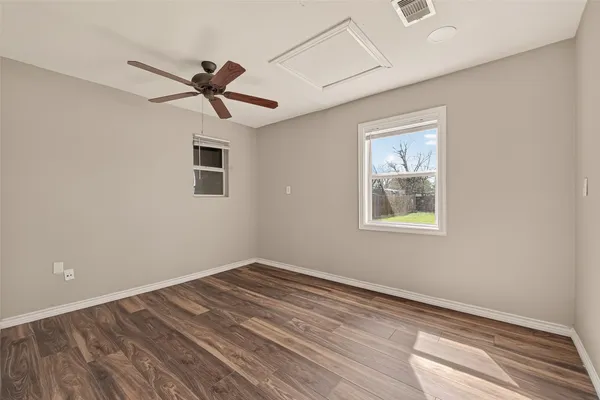 a view of empty room with wooden floor and ceiling fan