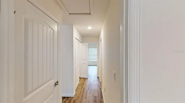 a view of a hallway with wooden floor and staircase