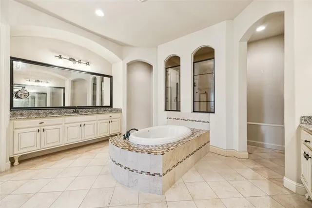 a spacious bathroom with a granite countertop sink and a mirror