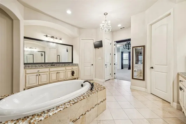 a spacious bathroom with a tub sink shower and mirror