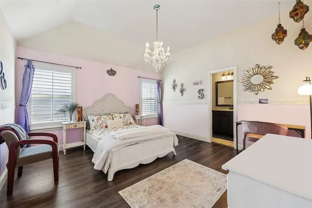 a bedroom with a bed chandelier and a window