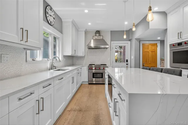 a large kitchen with stainless steel appliances granite countertop a lot of counter space and wooden floors