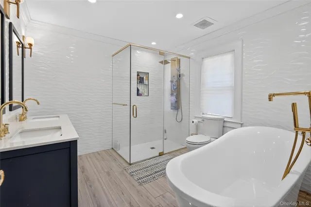 a bathroom with a tub sink shower and mirror