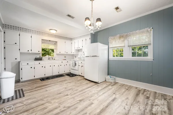 a kitchen with stainless steel appliances a refrigerator sink and white cabinets