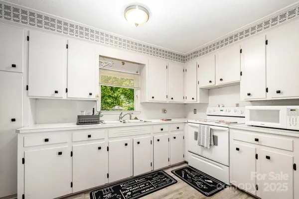 a kitchen with cabinets appliances a sink and a window