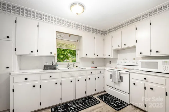 a kitchen with cabinets appliances a sink and a window